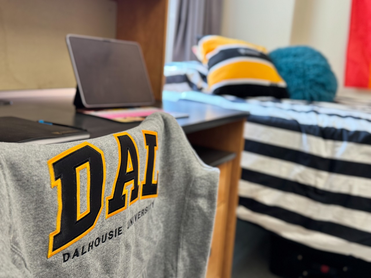 A close-up of a desk in a double room in Risley Hall, with a grey Dal sweatshirt draped over the back of the chair.