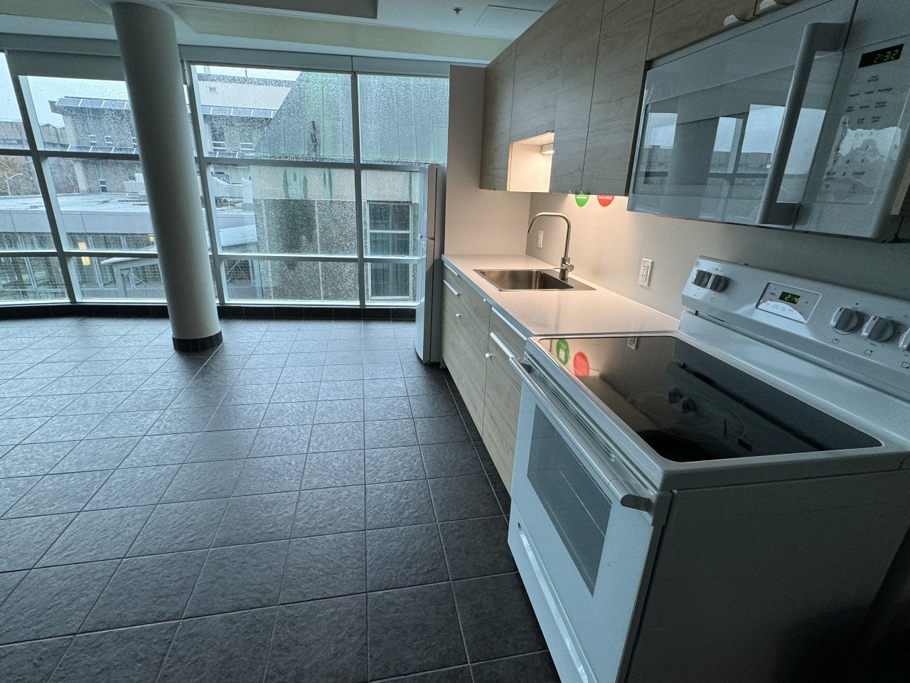A full kitchen in a lounge in Risley Hall, with modern light wood cabinets and white appliances