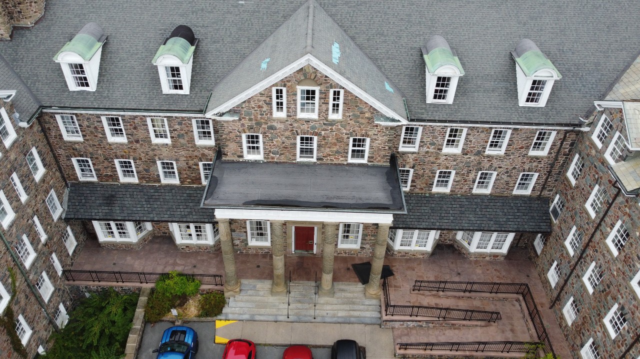 The front of Shirreff Hall as seen from above - with a large entryway with stone columns and an accessible ramp.