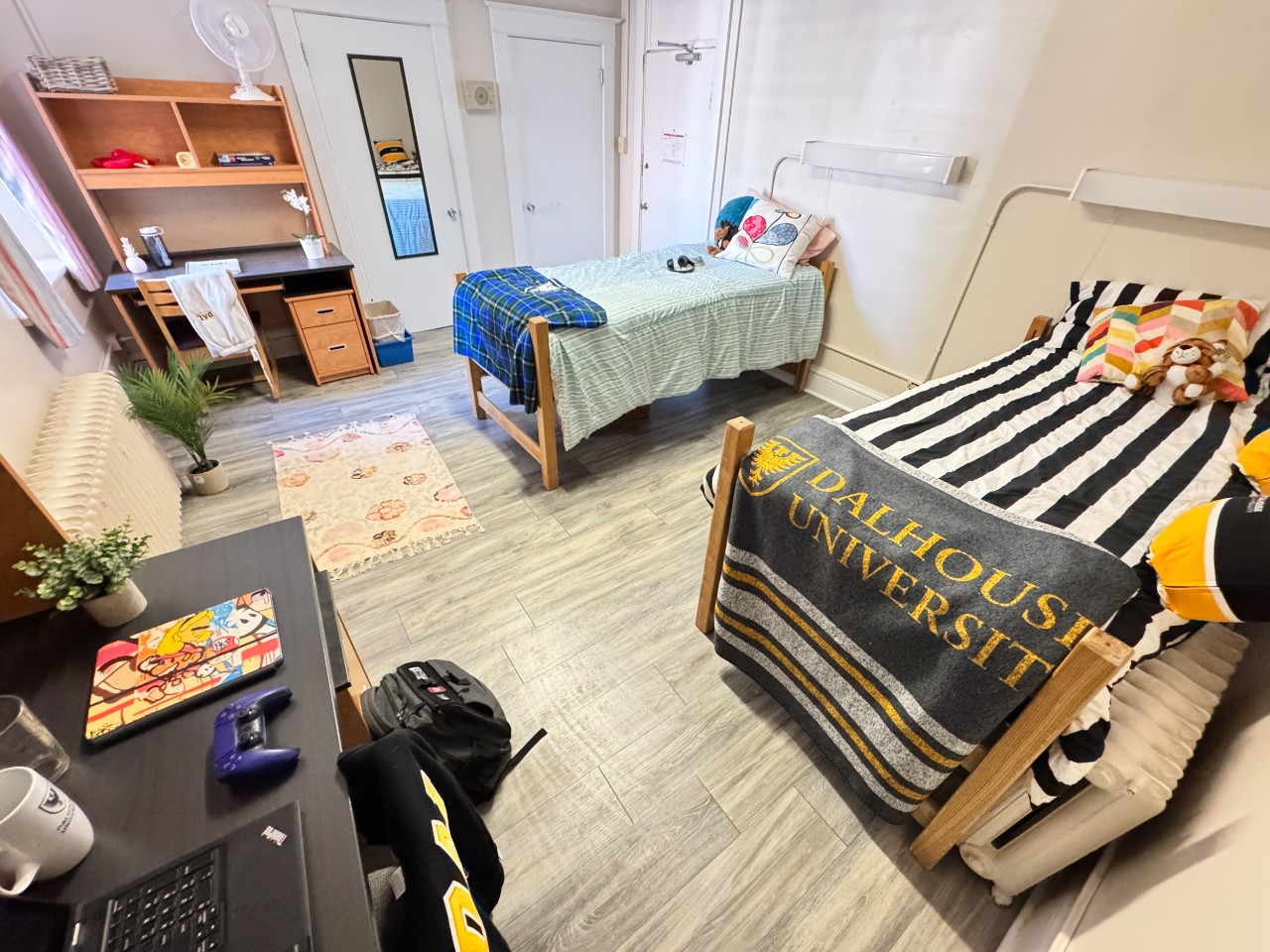 This double room has two beds, two built-in closets, two desks, and modern grey floors.