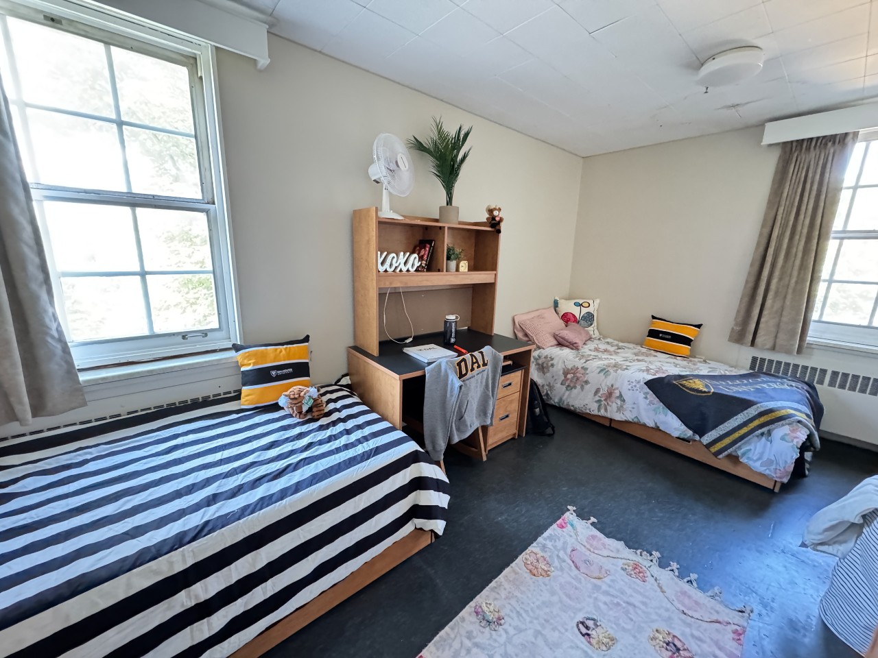 This double room in Newcombe House has two beds with storage, placed at 90 degrees. It also has desks and storage for clothes.