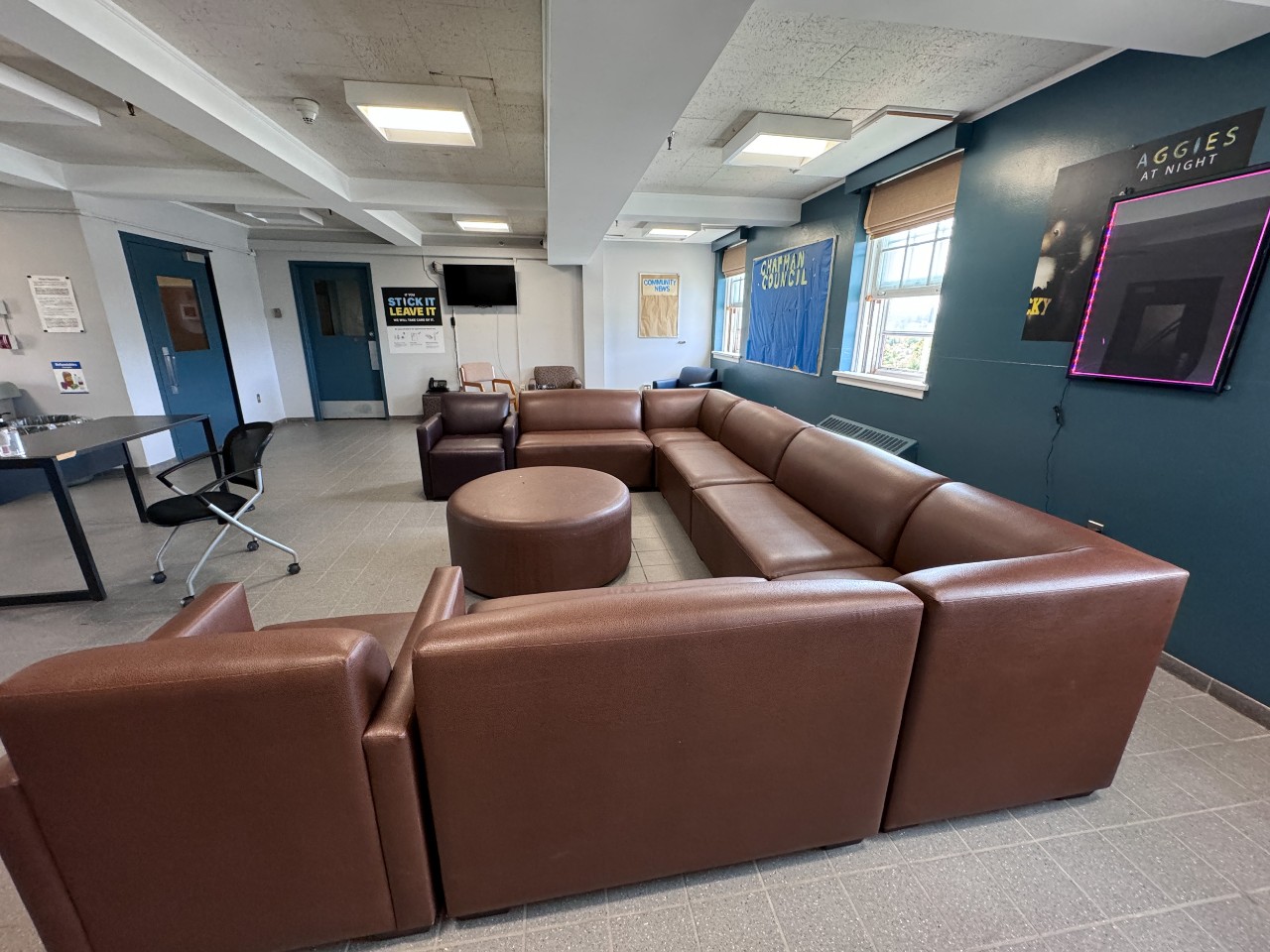 The lobby of Chapman House, with a brown leather sectional and blue painted wall.