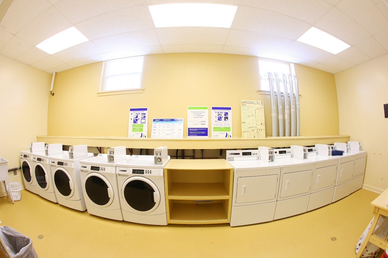 A laundry room on the agricultural campus with multiple coin-operated washers and dryers.