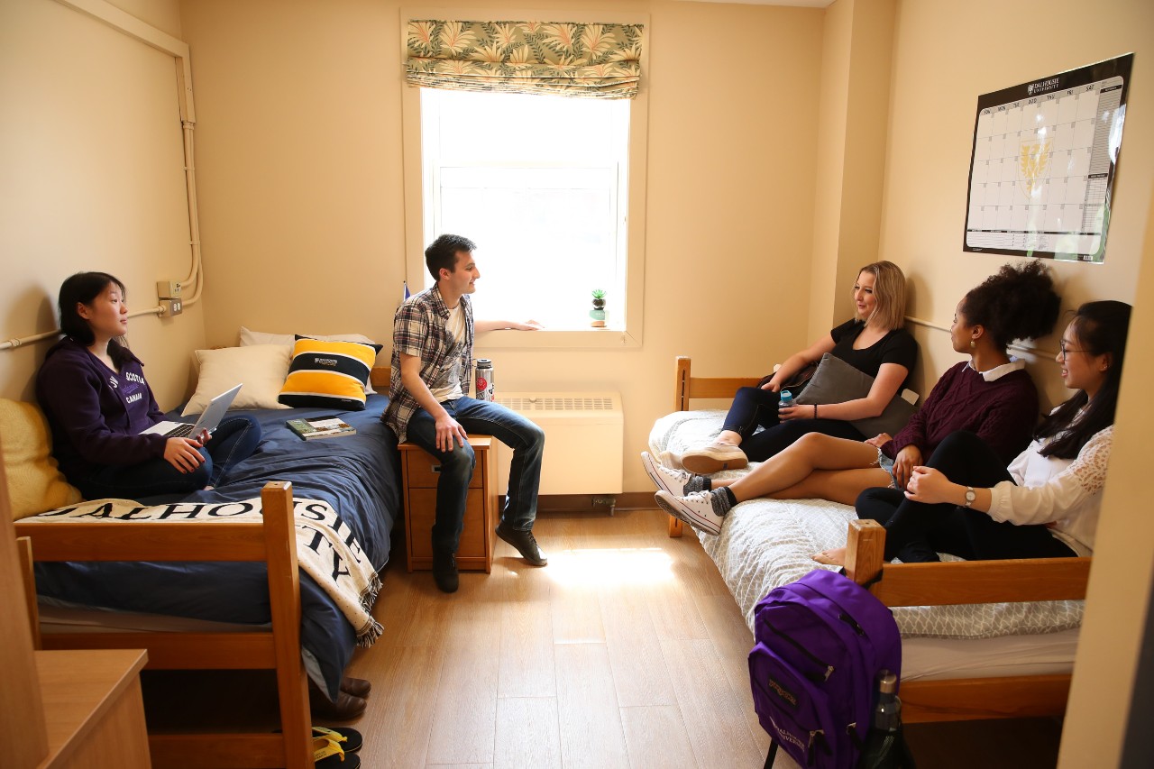 A double room in Chapman House, with students sitting on the beds socializing