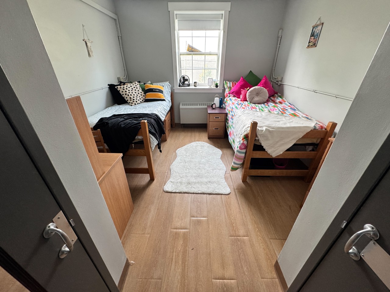 A double room in Fraser House, with brightly coloured blankets on the beds and posters on the walls.