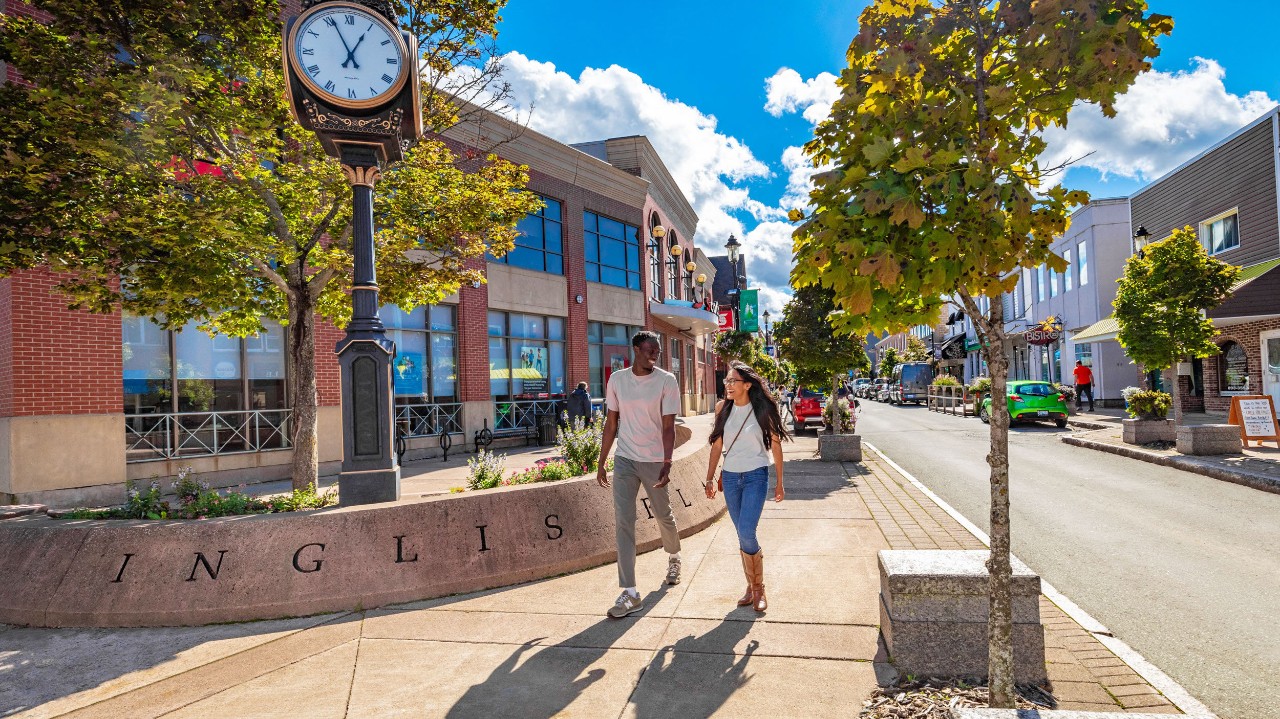 A young couple walks on a sidewalk in Downtown Truro