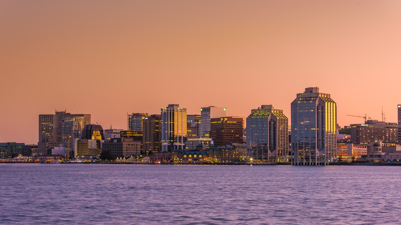 The Halifax Skyline from across the harbour at sunset with an orange sky