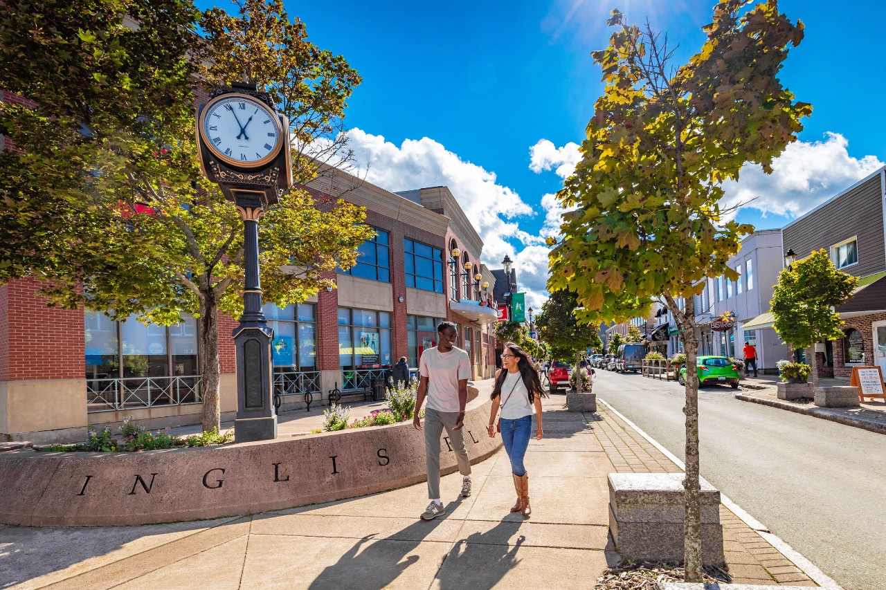 A young couple walks on a sidewalk in Downtown Truro