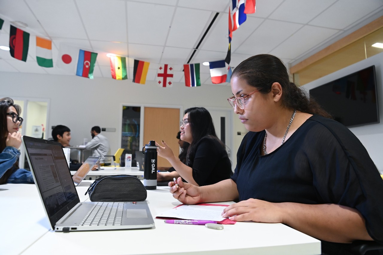 A student does work in front of a laptop in the International Centre.