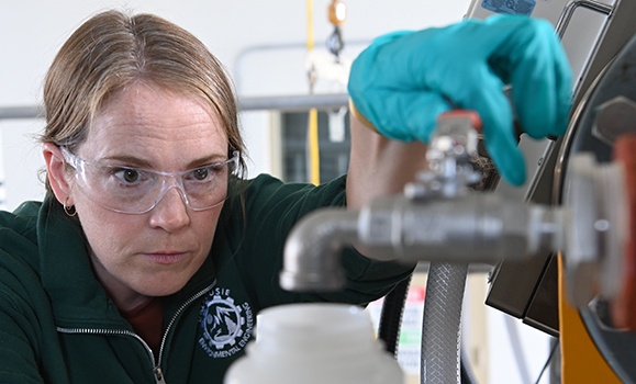 Water researcher Dr. Amina Stoddart prepare to take a wastewater sample.
