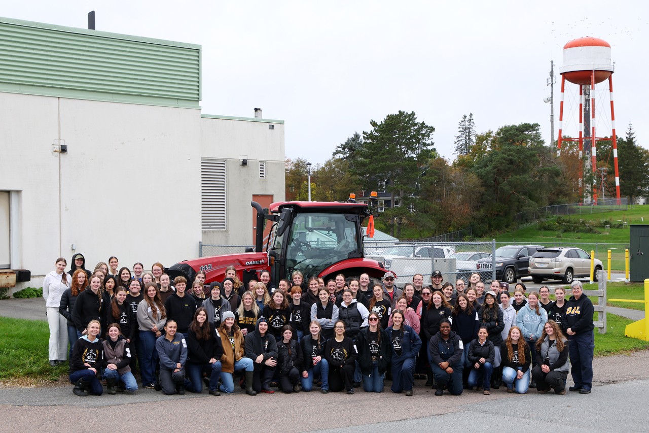 Students posing in front of a Case tractor for College Royal