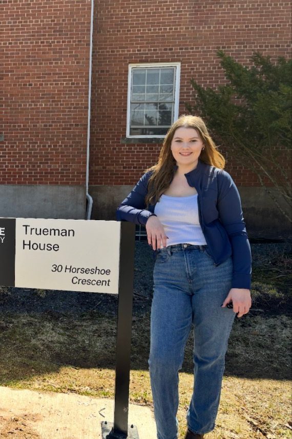 Alexandra Carkner standing next to the Trueman House sign
