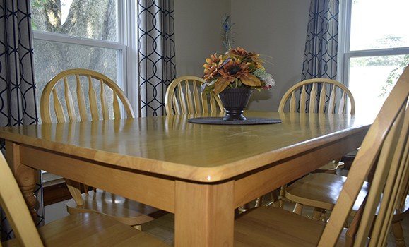LIght wood dining room table with chairs.