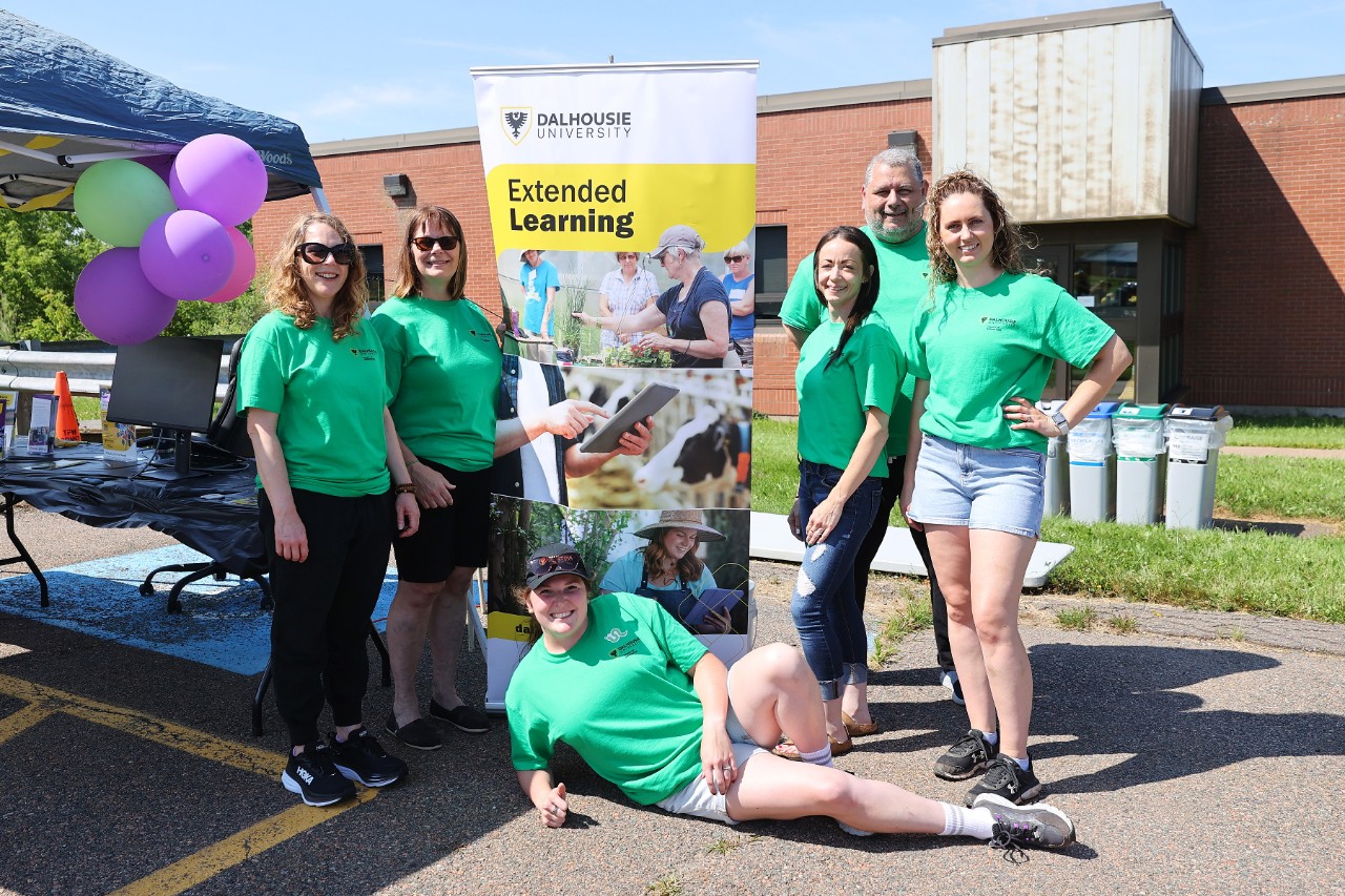 6 members of Dal staff and faculty in green t shirts standing in front of Extended Learning sign at Dal's agricultural campus community day