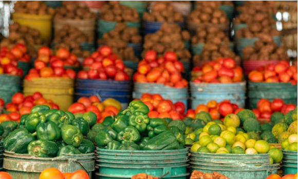 Multple baskets of colourful peppers for sale in a market