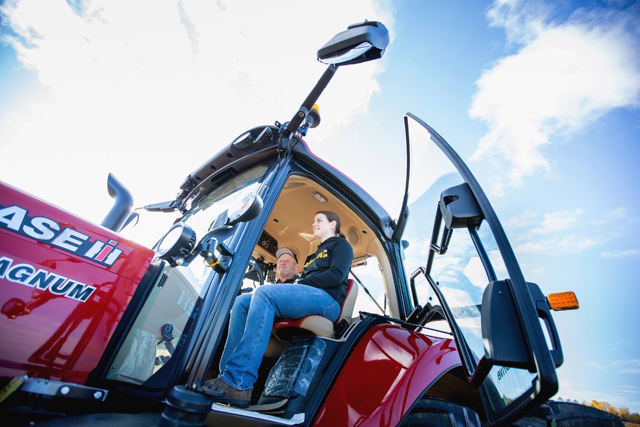 Student and instructor seated in a modern tractor equipped for digital agriculture.