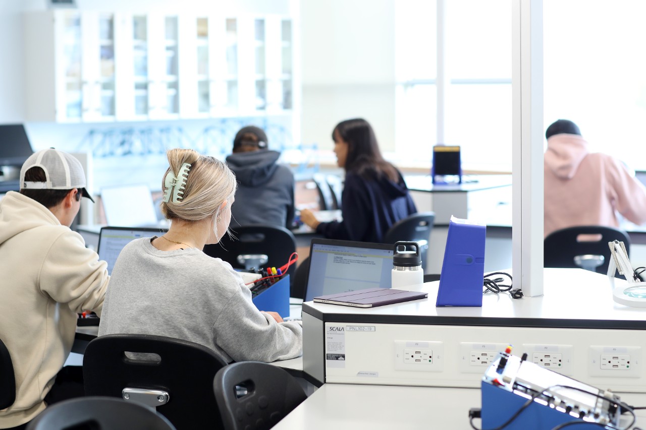 Students working at computers at various desks