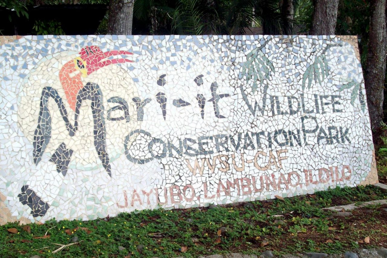 A tile mosaic sign featuring an image of a black and white bird with a red beak that reads "Mari-it Wildlife Convervation Park."