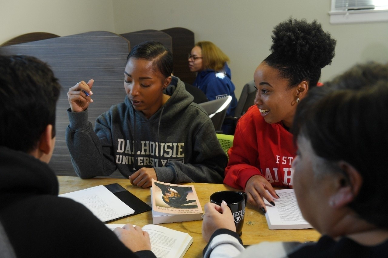 Group of students sitting around a table with open books.