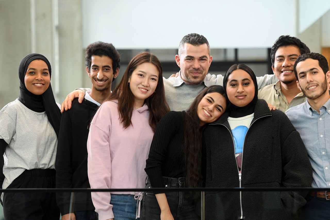 A group of international students pose in the mona campbell building