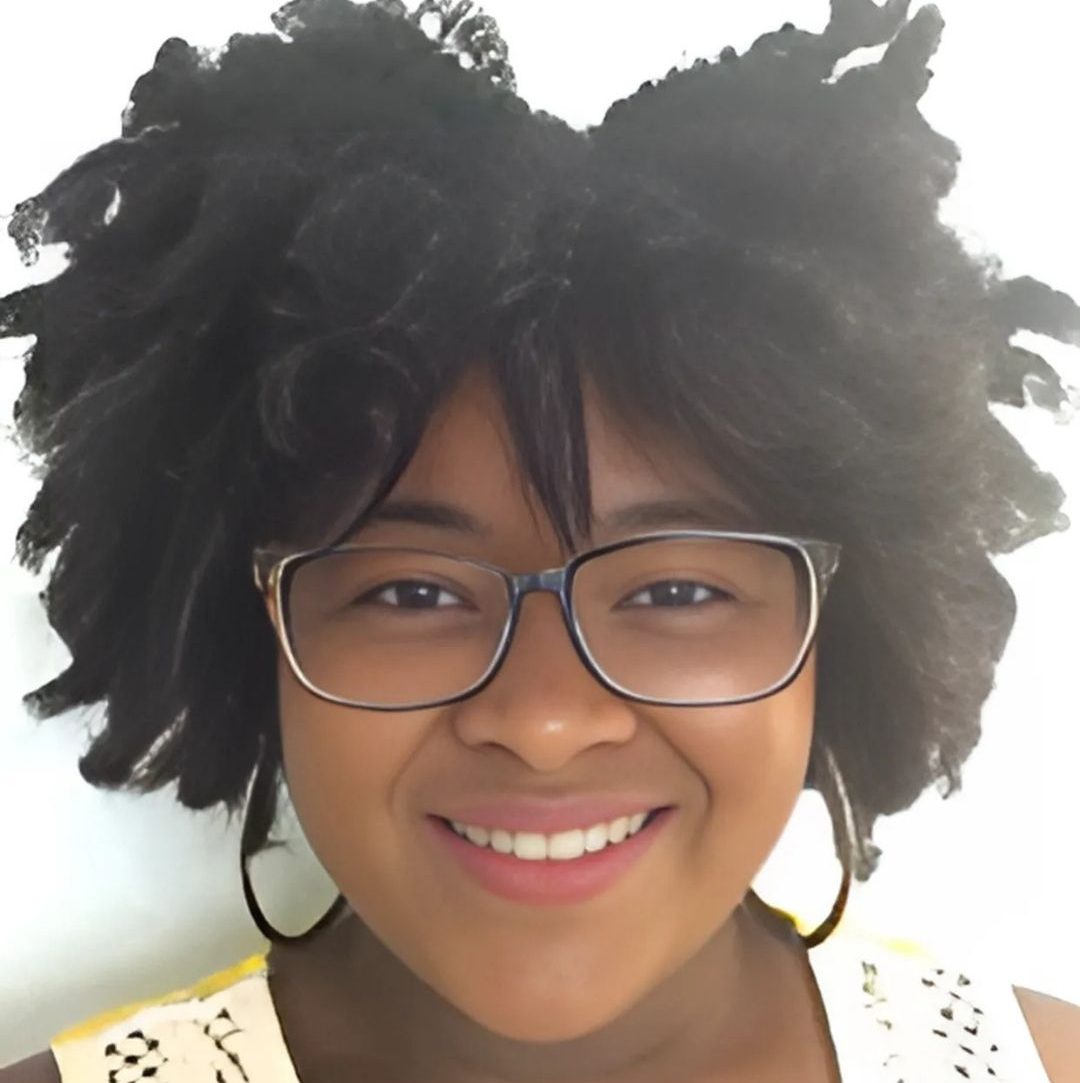 Close-up of smiling Black woman wearing glasses.