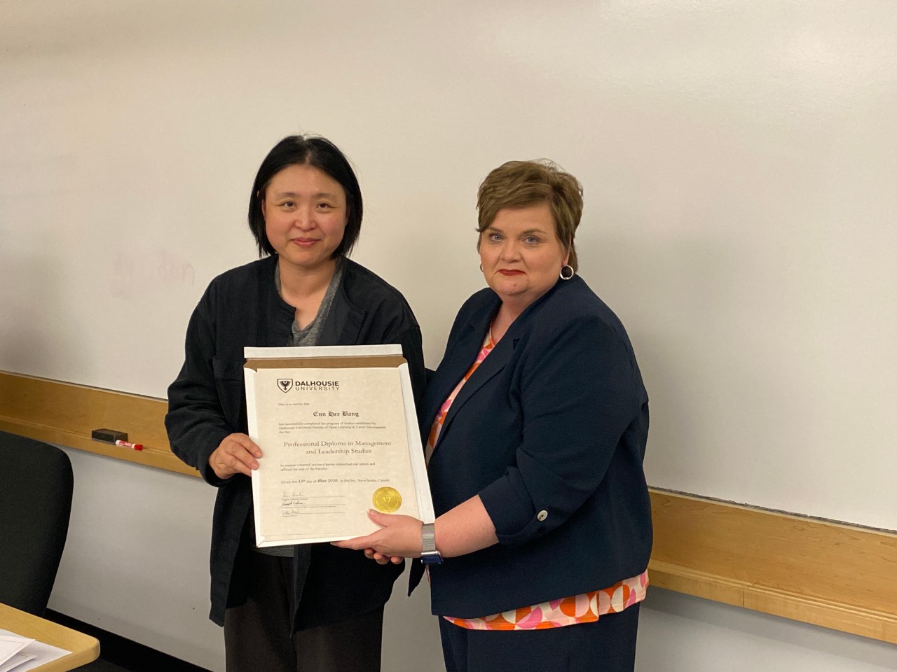 Eun Hee Bang receiving diploma from Jennifer Hann