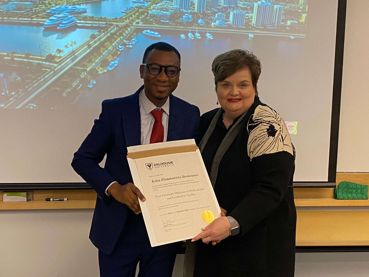 Rufus Akinbolusere accepts diploma from acting dean Jennifer Hann