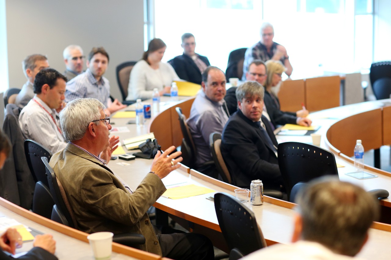 Family business members sit around a lecture hall. 