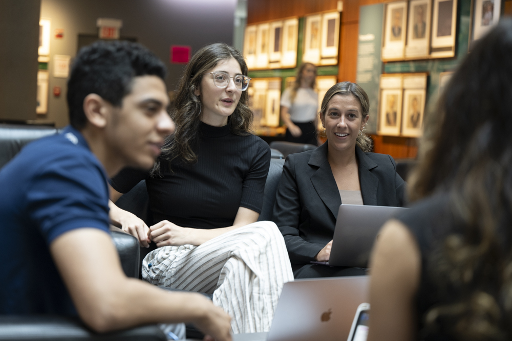 A group of students in discussion, sitting on couches.  