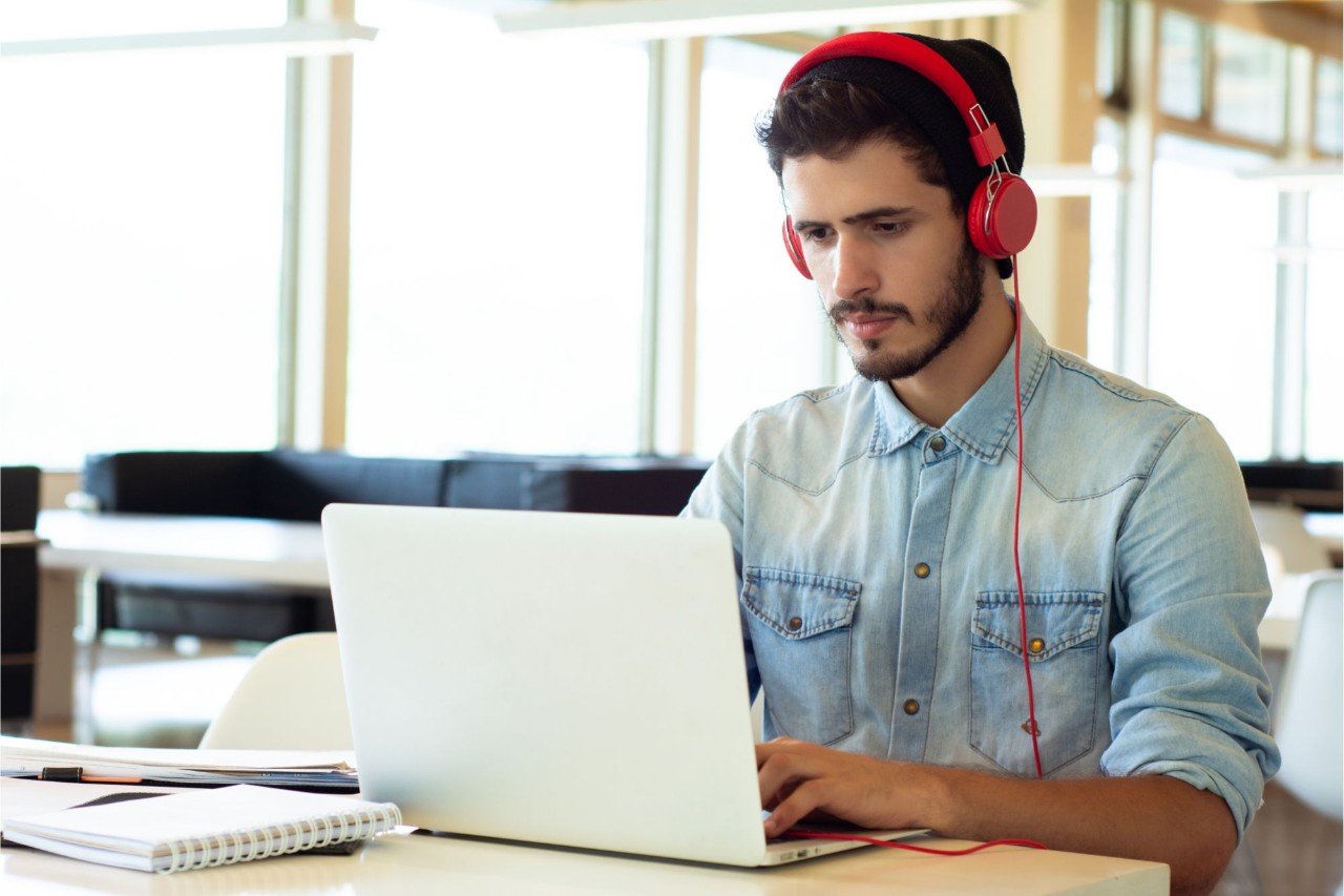 Man with red headphones at laptop