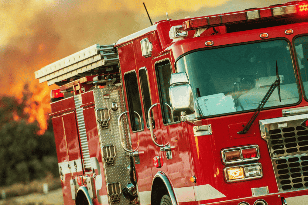 A fire truck driving away during a fire.