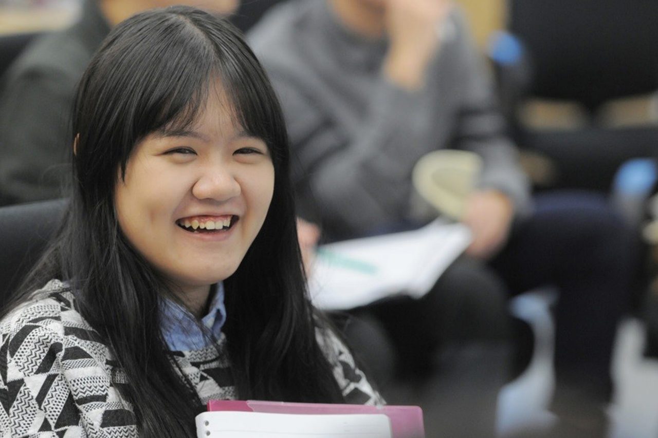Student with long, dark hair sitting in classroom.