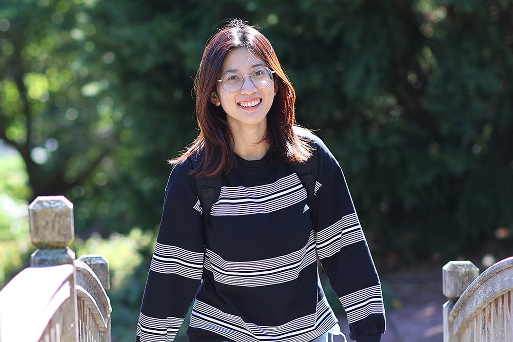 Student walking on wooden footbridge