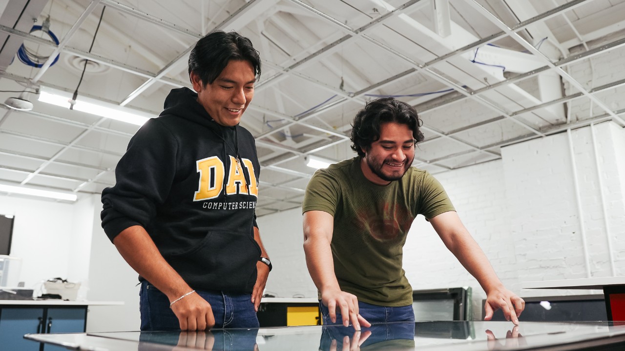 Two computer science students at Dalhousie collaborate on a large touchscreen table.