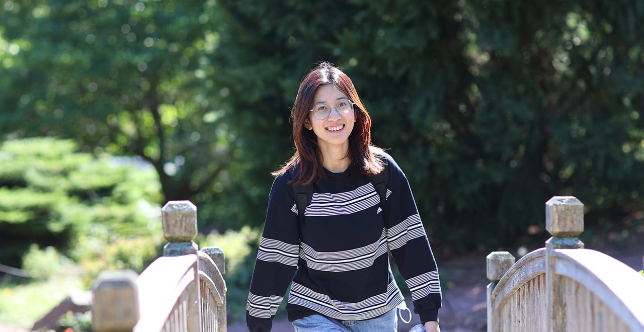 Student walking on wooden footbridge