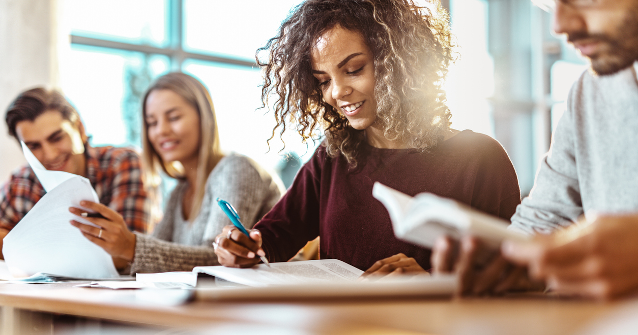 Four students writing and working on school