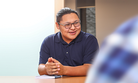 A group of students working together in a study hall to complete course work.