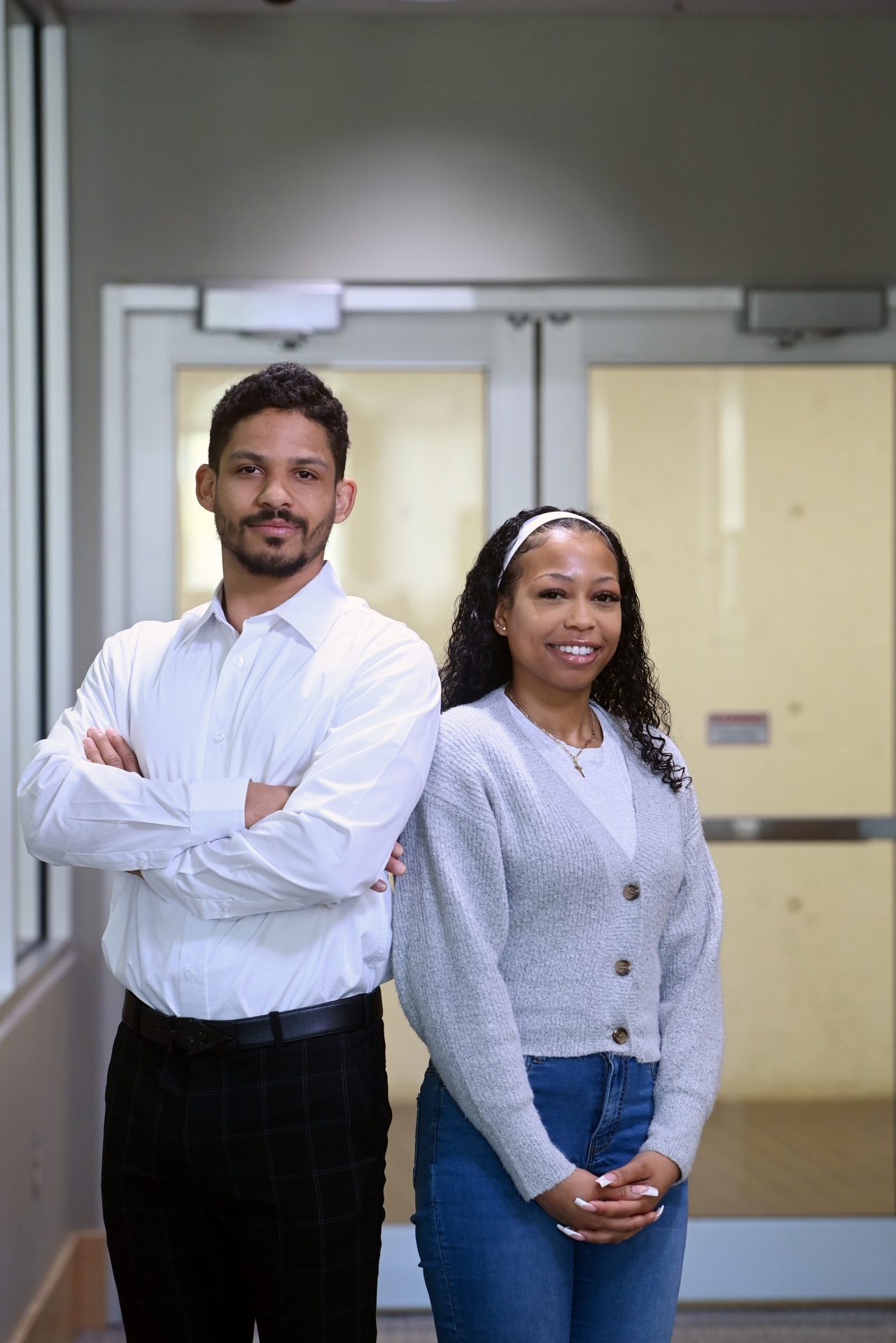 two of the first students of the BAFD graduating class standing back to back in hallway