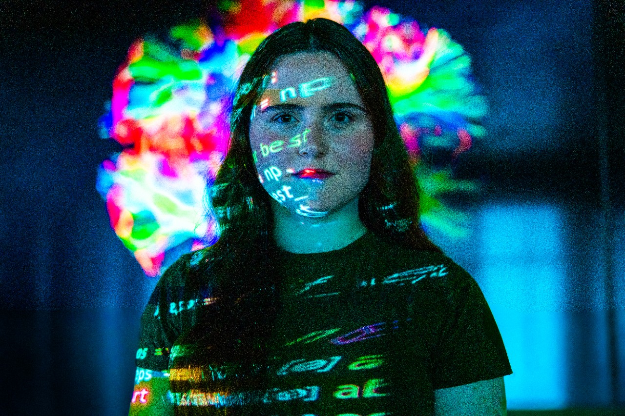 computer science student with code projected on her and the background
