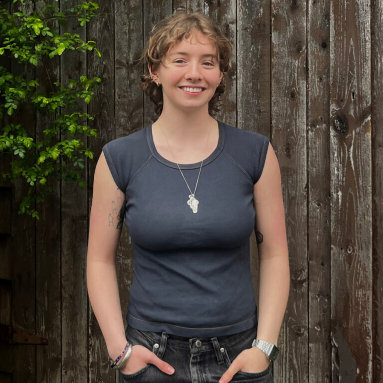 A square outdoor portrait of University of King’s College graduate Sam Flood smiling.  