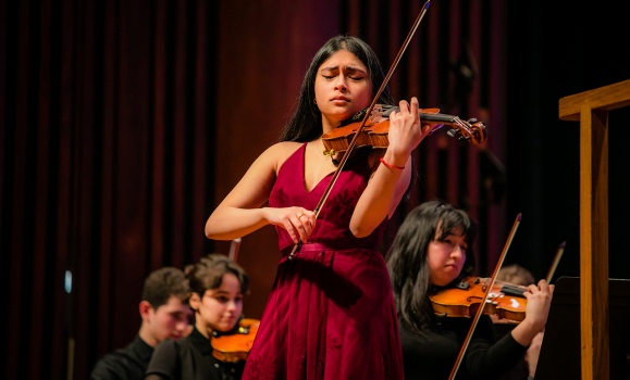 Music student Shanti Sivarulrasa playing violin on stage