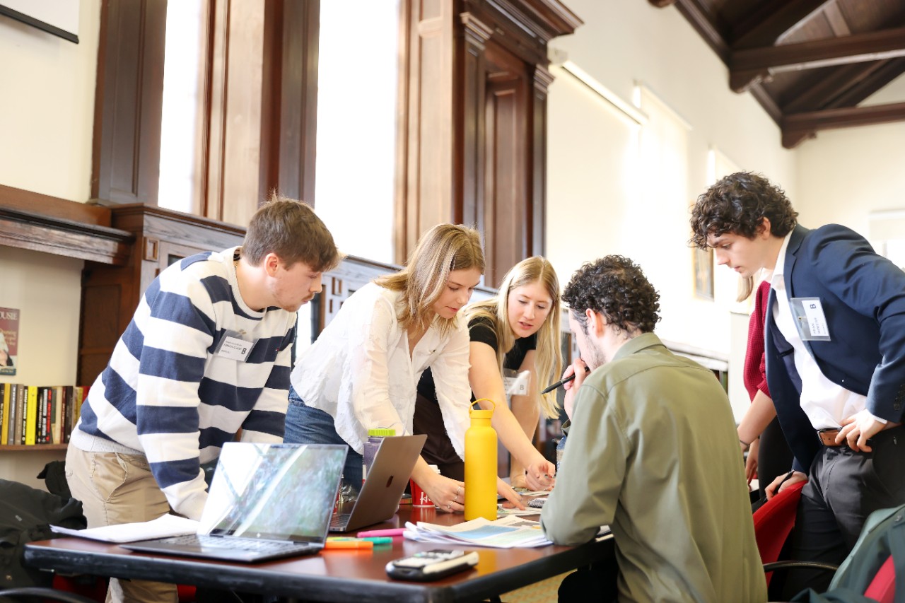 Group of students around a table collaborating on work