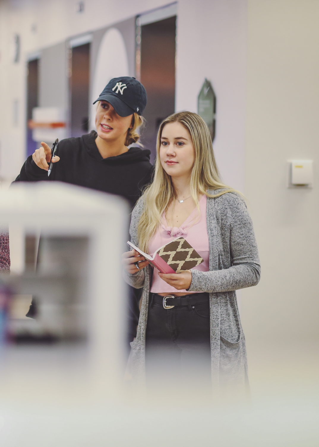 Two students doing field work together in a library