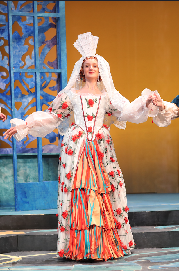 Theatre student in a dress on stage during a rehearsal of Molière.