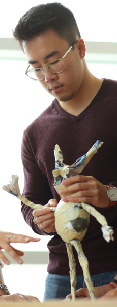 Theatre Studies student with puppet in class