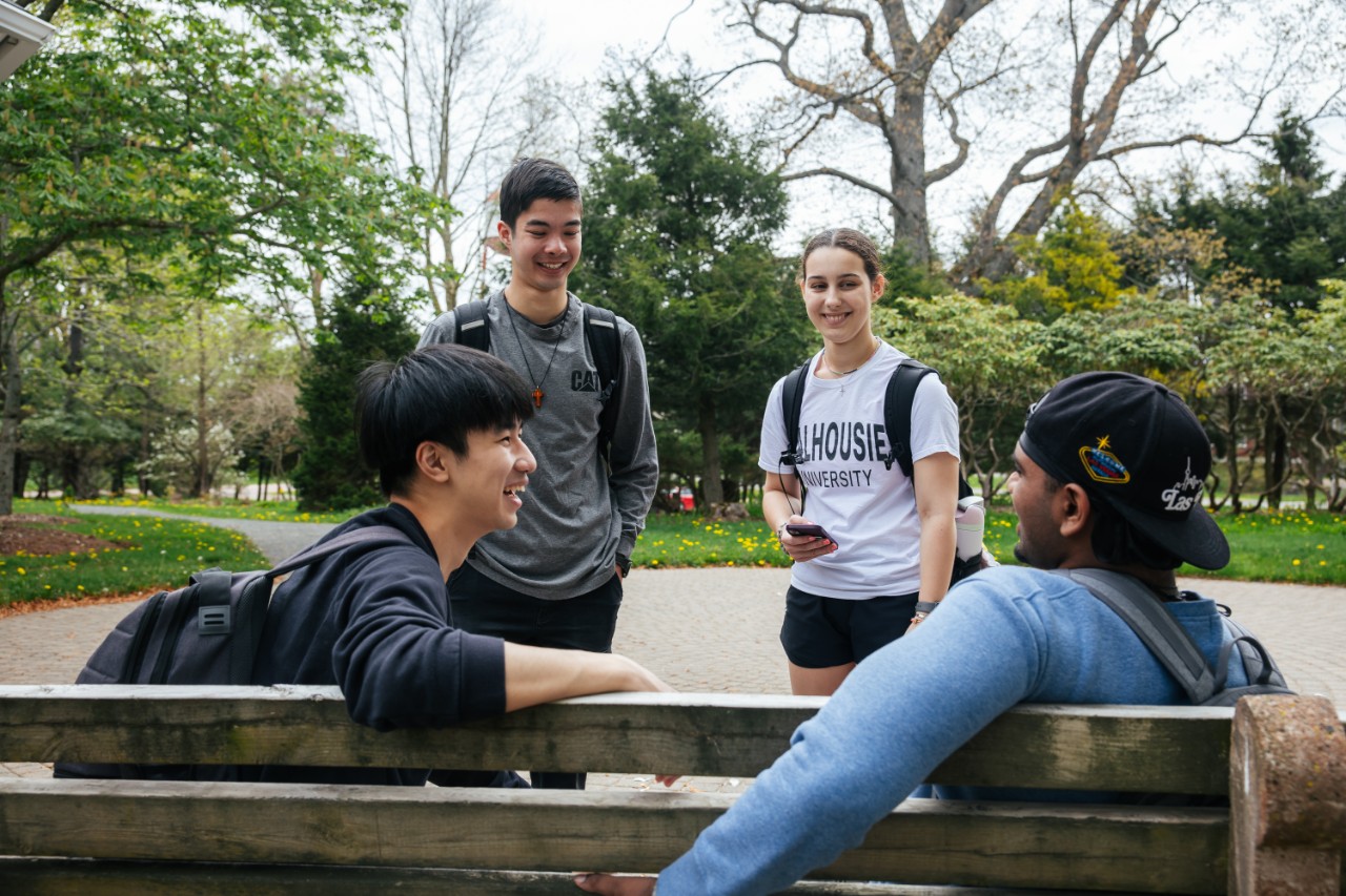 four students in the Alumni gardens talking