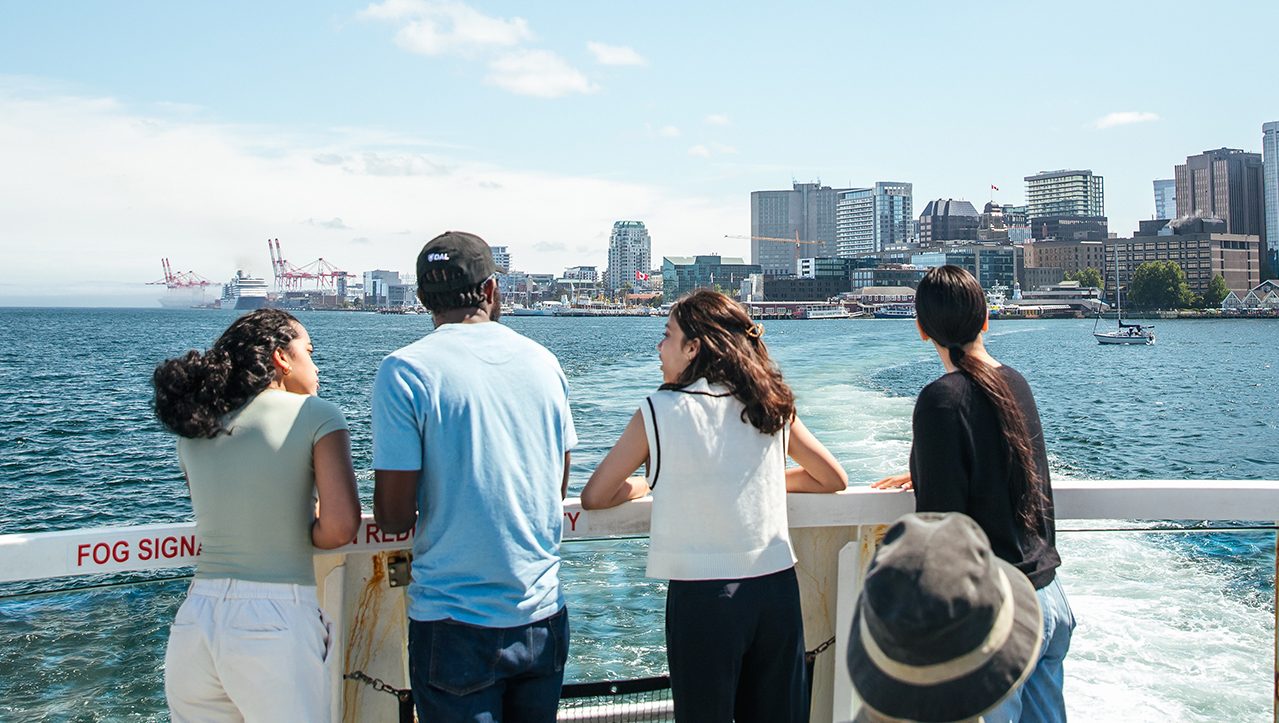 student on the halifax ferry facing toward downtown Halifax