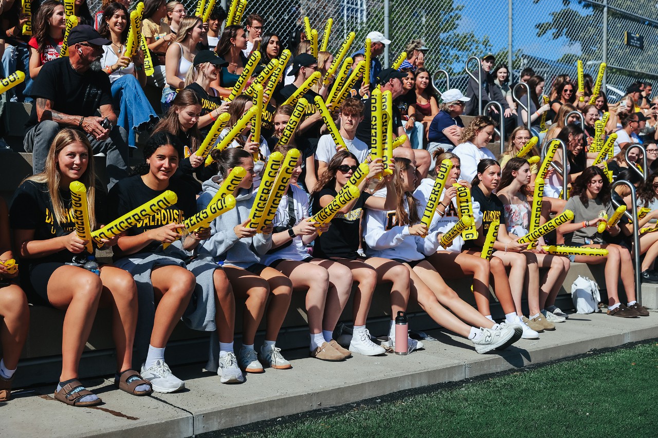 students cheering a team on Wickwire field