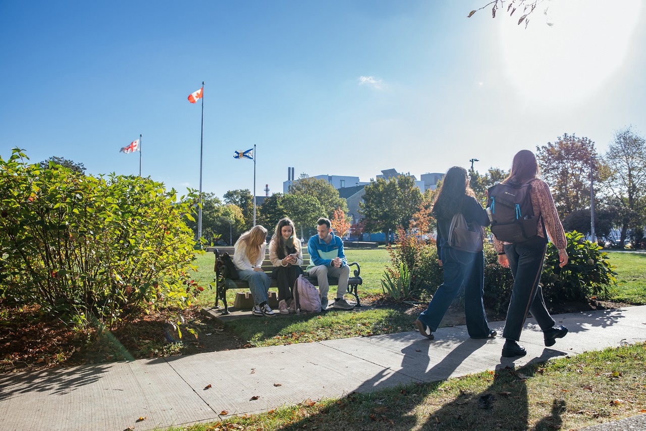 students walking and on bench in Studley Quad